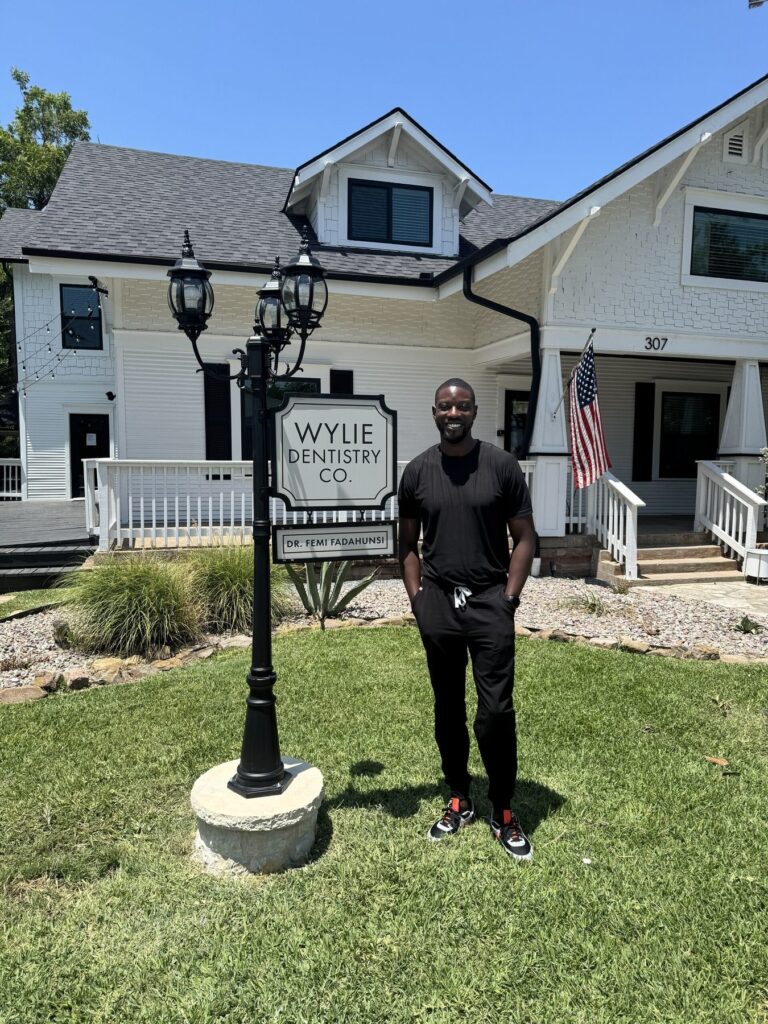 Dr. Femi Fadahunsi outside the Wylie Dentistry Co. office sign